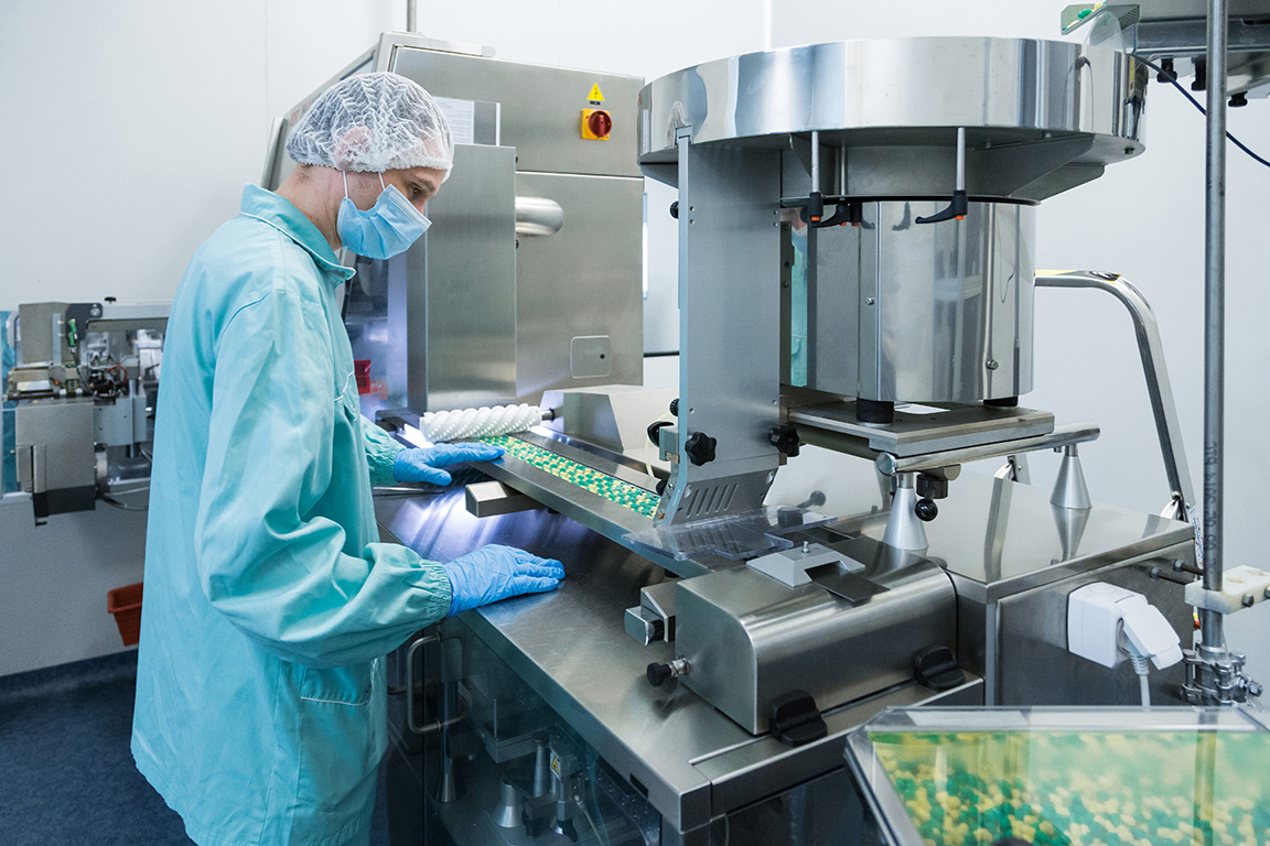 pharmaceutical industry man worker protective clothing operating production tablets sterile working conditions
